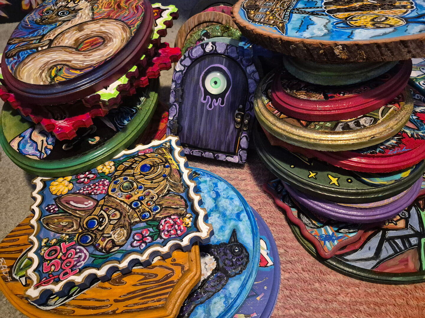 A collection of Erin B’s acrylic paintings on colorful round wood plaques